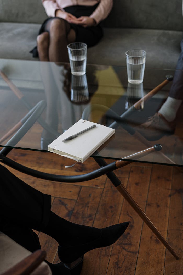 Mastering the First Impression: Your intriguing post title goes here Close-up of a counseling session with two glasses of water and a notepad on a glass table.